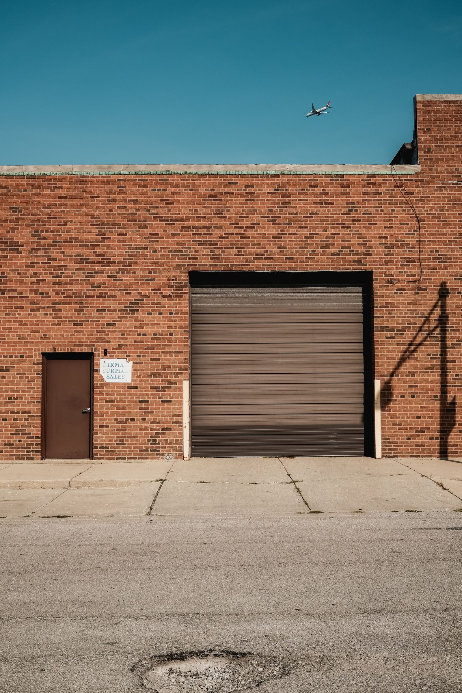 A brick industrial unit with a roller shutter door