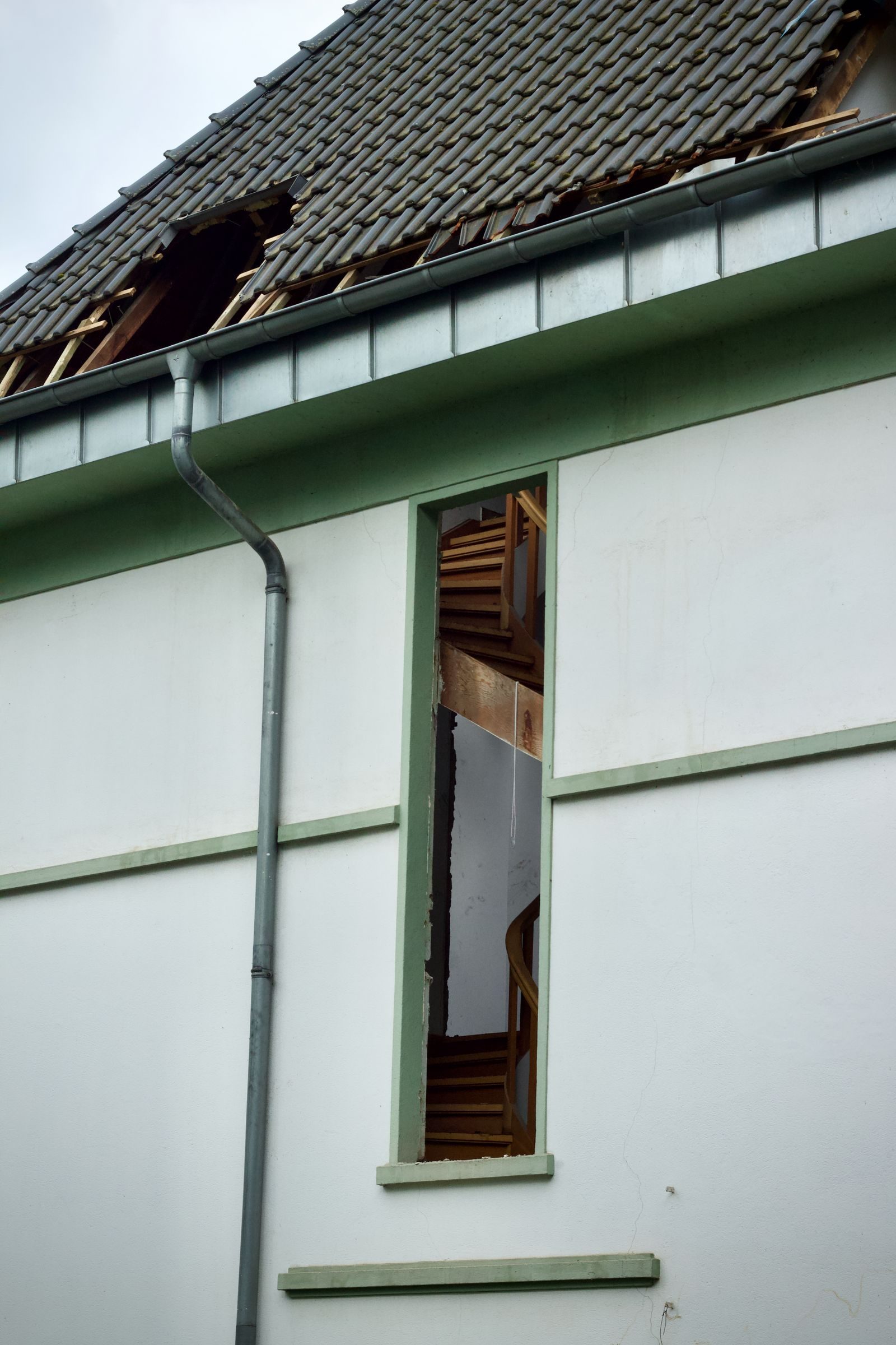 A white house with guttering and a dormer window